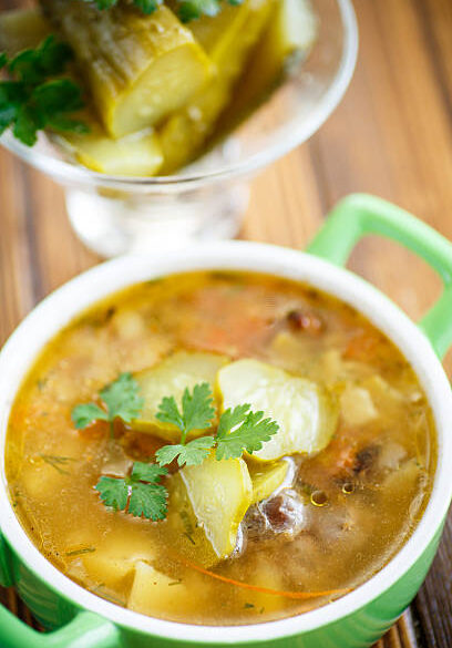 soup with pickled cucumbers on the plate on a wooden table